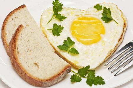 fried egg in a heart shape with bread