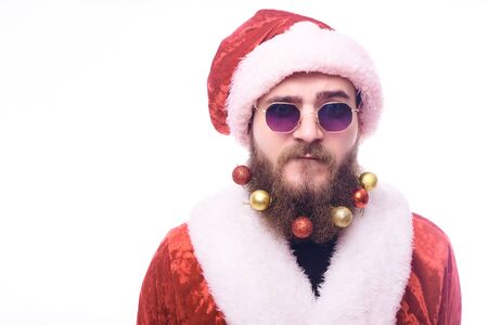 man in Santa Claus costume, black glasses and Christmas toys in the beard Copy-Spaceのeditorial素材