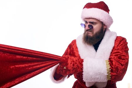 Man dressed as Santa Claus pulls on a red bagのeditorial素材