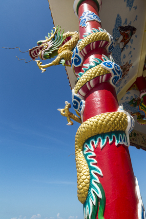 Golden Chinese Dragon Wrapped around red pole.の写真素材