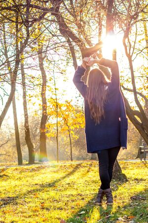 beautiful girl at sunset in autumn forestの写真素材