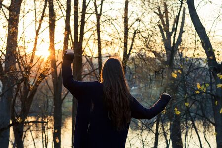 beautiful girl at sunset in autumn forestの写真素材