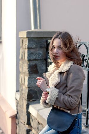 young attractive girl on the background of buildings at sunsetの写真素材