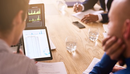 Business meeting taking place with diverse group of business people in a modern office with several...
