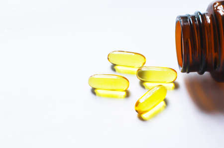Fish oil capsules on white background and texture., Fish oil capsules and container., selective...