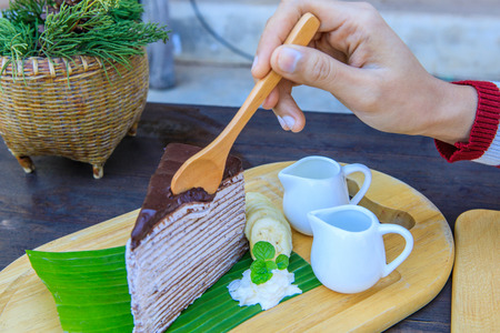 Chocolate cake in banana leaf on wooden table.の写真素材
