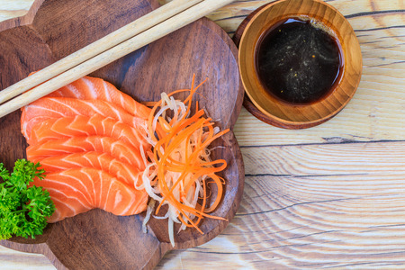 Salmon sashimi in wooden bowl on the table.の写真素材