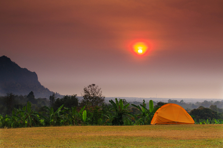 The orange hiker's  tent on the lawn in the morning.の写真素材