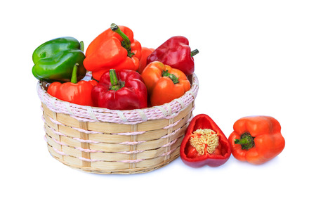 The bell pepper in the bamboo basket isolated on white backgroundの写真素材
