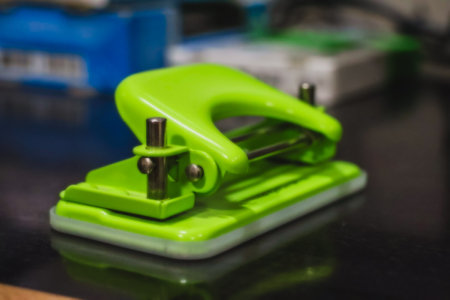 Green stapler on a black background. Shallow depth of fieldの写真素材