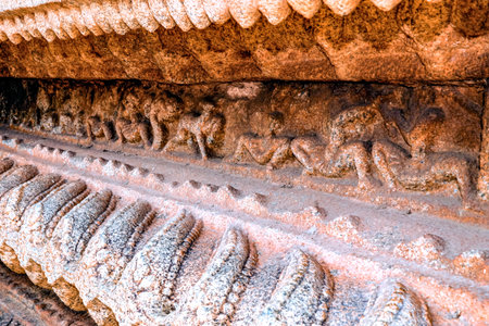 Ancient stone relief carving at Hampi depicts mythological figures and animals with remarkable...