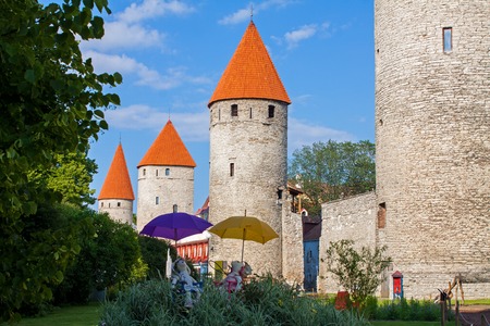 Summer garden, fortress walls and towers of Tallinn, Estonia old town. Europe tourist attractions.