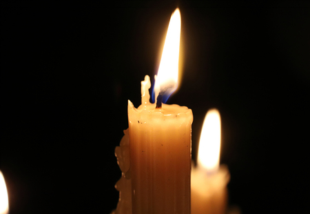 Close up of burning wax candles in the dark. Candle flame, candlewick. Christmas, New Year, greeting card, All Saints Day, All Hallows Eve, church, religion, faith, prayer, holiday, magical.の写真素材