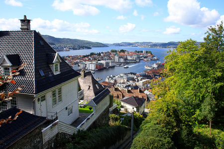 Sunny Bergen with Mount Floyen funicular rails. Skyline, clouds, fjord, mountains, cityscape, bay, yachts, boats, ferry, ship, church, houses, hill, trees. Norway, Scandinavia, tourism, landmark.の写真素材