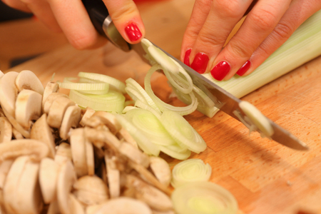 slicing mushrooms and leek onionsの写真素材