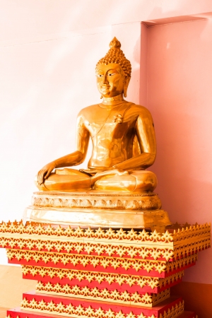 Sitting bronze buddha image statue at sideの写真素材