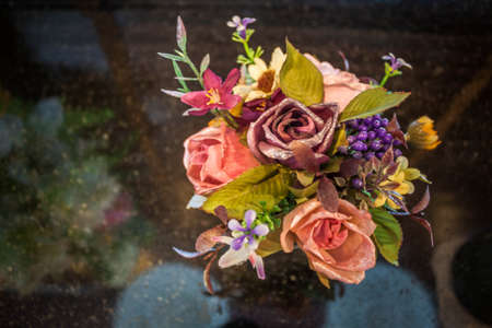 Beautiful colors of plastic flowers on granite tableの写真素材