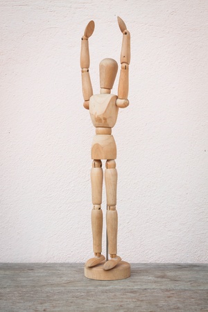 Raising hands up and standing wooden poserの写真素材