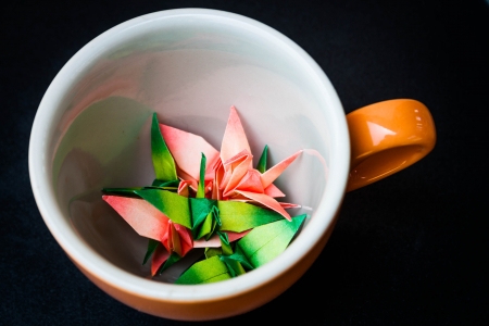 Mug cup of paper birds on dark backgroundの写真素材