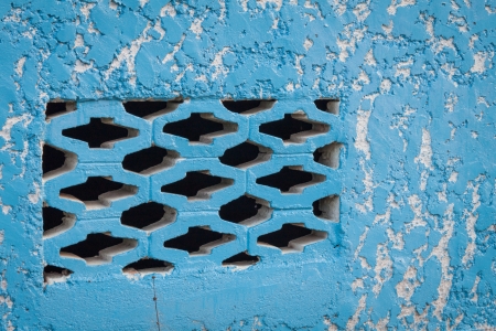 Blue aged street wall with black brick holesの写真素材