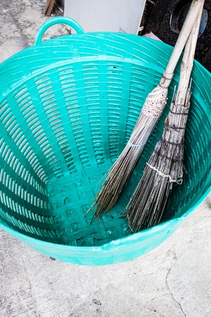 Old brooms after sweeping keep in plastic basketの写真素材