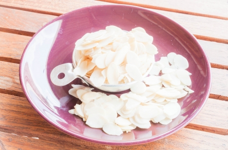 Bakery raw sliced almonds in measured cupの写真素材