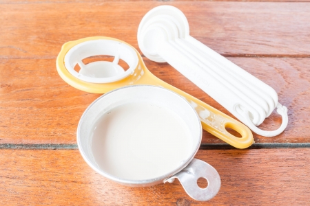 Beginning step of bakery preparation with milk, spoon and yolk separatorの写真素材