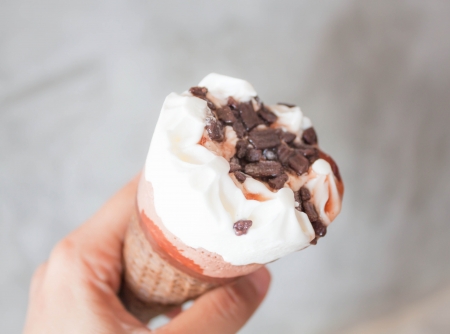 Melted ice cream in waffle cone in handの写真素材