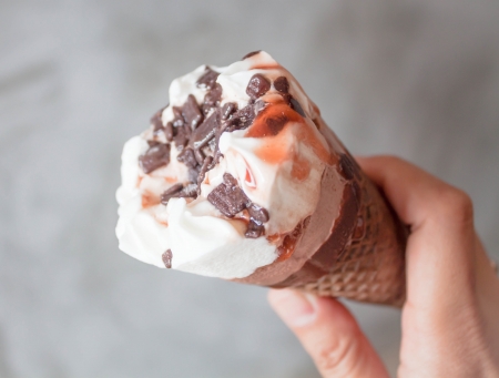 Melted ice cream in waffle cone in handの写真素材
