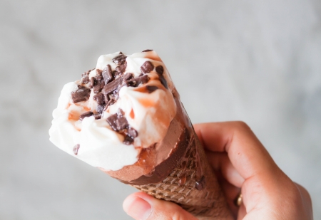 Melted ice cream in waffle cone in handの写真素材