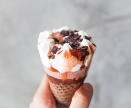 Melted ice cream in waffle cone in handの写真素材