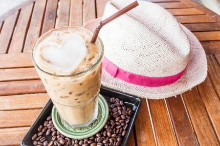 Cold glass of iced milk coffee on wood tableの写真素材