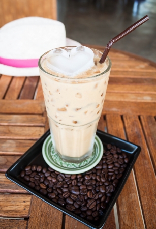Cold glass of milk espresso and heart ice cubeの写真素材