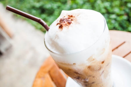 Refreshing glass of iced blended frappucino with milk foamの写真素材