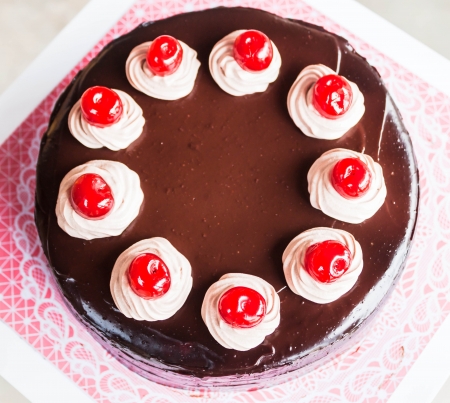 Chocolate cake with whipped cream and cherryの写真素材