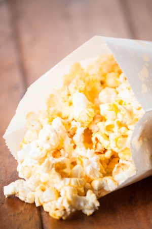 Fresh popcorn in paper bag on wood tableの写真素材