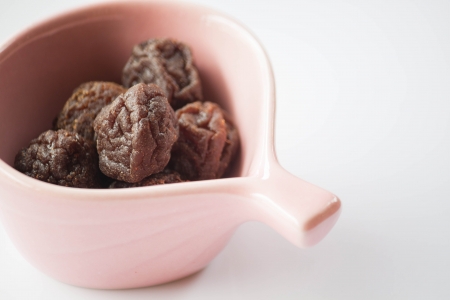 Sweet dried pink plum in cup up closeの写真素材
