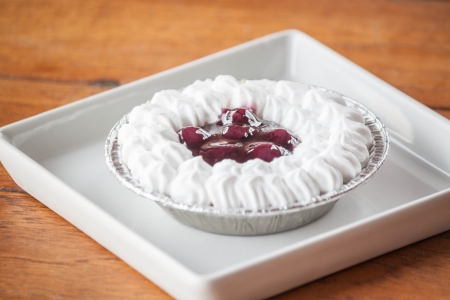 Blueberries cheese cupcake with whipped cream on a plateの写真素材