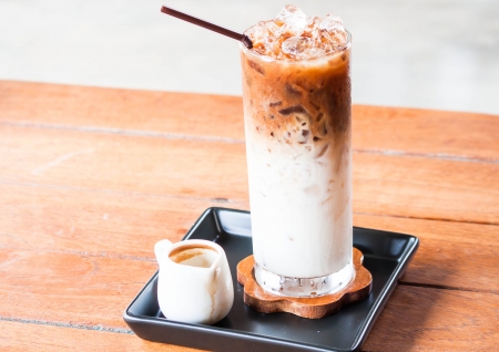 Glass of cold coffee latte with espresso pitcherの写真素材