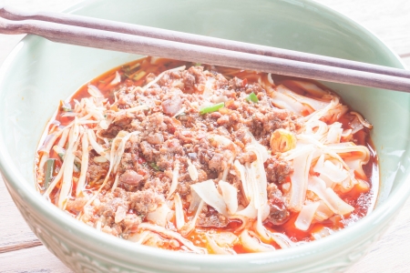 Spicy noodle soup with chopsticks up closeの写真素材