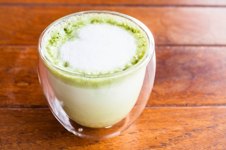 Glass of hot matcha green tea latte with milk microfoamの写真素材