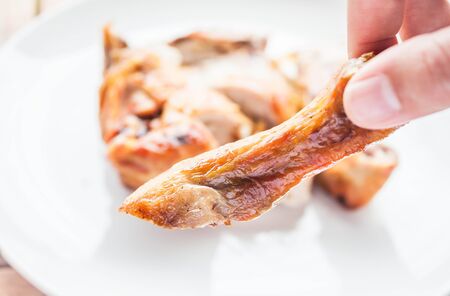 Hand on grilled chicken legの写真素材