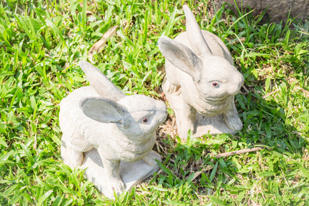 Twin rabbits of plaster decorated in green grass, stock photoの写真素材