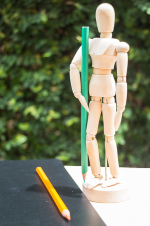 Wood artist mannequin standing with colour pencilの写真素材