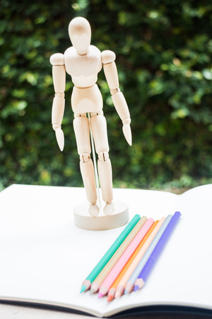 Wood mannequin standing on artist drawing paperbookの写真素材