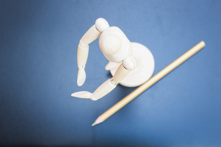 Wooden mannequin and pencil on dark background, stock photoの写真素材