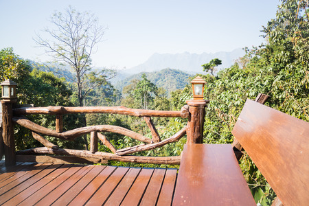 Outdoor wooden seating area with green forest scenery, stock photoの写真素材