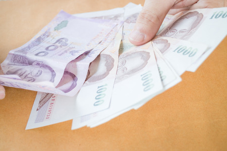 Man hand counting Thai baht banknote, stock photoの写真素材