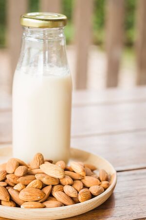 Bottle of almond milk on wooden table, stock photoの写真素材