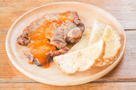 Pork steak on wooden plate, stock photoの写真素材